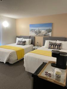 a hotel room with two beds with yellow and white sheets at Paradise Inn On the Beach in Port Elgin