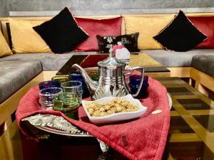 a coffee table with a tea pot on a red towel at Riad Dades Paradise in Boumalne Dades