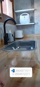 eine Spüle in einer Küche mit einem Schild auf einem Holzboden in der Unterkunft Depto del Centro in San Rafael + 4 Fotos