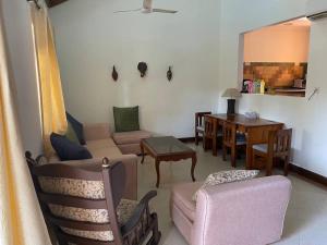 a living room with a couch and chairs and a table at 2BHK Pool Facing Beachside Luxury Homestay In South Goa in Betalbatim