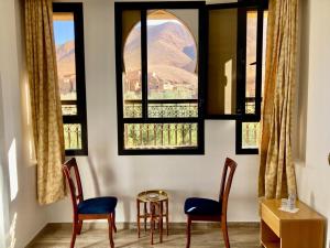 a room with two chairs and a table and two windows at Riad Dades Paradise in Boumalne