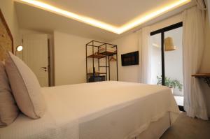 Un dormitorio con una gran cama blanca y una ventana en Villa Santa Fé, en Búzios