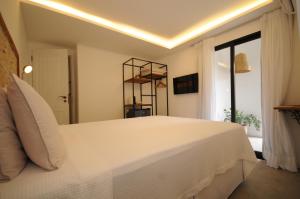 a bedroom with a large white bed and a window at Villa Santa Fé in Búzios