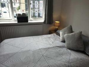 una camera da letto con un letto con due cuscini e una finestra di Lakeshore a Kent