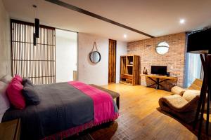 a bedroom with a bed and a living room at Múbú Hotel Boutique in Valle de Bravo