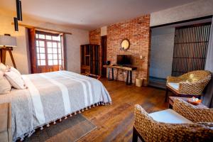 a bedroom with a bed and a chair and a television at Múbú Hotel Boutique in Valle de Bravo