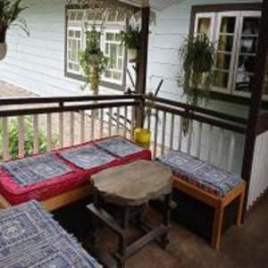 a balcony with a table and a stool and a house at Rinzeebong Homestay by StayApart in Mangan