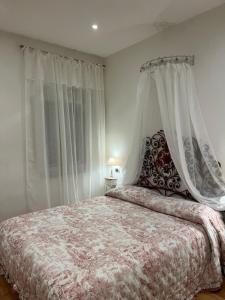 a bedroom with a bed with a canopy and curtains at Frida in Viareggio