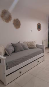 1 cama blanca con almohadas en una pared blanca en Alquiler temporario en Tandil