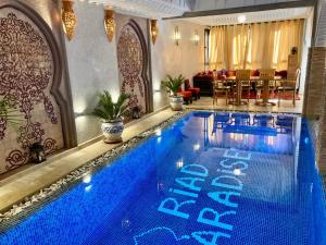 a large blue swimming pool in a room at Riad Dades Paradise in Boumalne