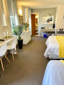 a hotel room with a bed and a desk and a sink at Paradise Inn On the Beach in Port Elgin