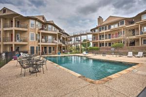 a swimming pool with chairs and a table and some apartments at Resort Condo in Pottsboro with Lake Texoma Access! in Pottsboro
