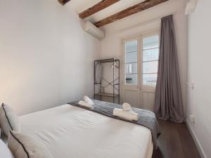 a white bedroom with a bed and a window at Stay U-nique Apartments Vila de Gracia in Barcelona