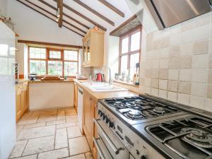 a large kitchen with a stove top oven at Manor Farm House in Norwich