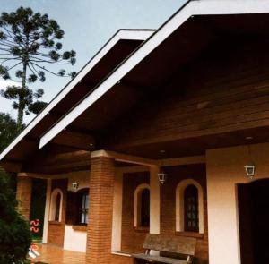 une grande maison en briques avec un toit dans l'établissement Pequeno Paraiso, à Campos do Jordão