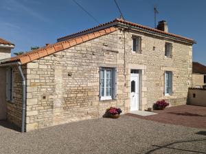 een stenen huis met een witte deur op een gebouw bij Gîte Puyréaux, 3 pièces, 4 personnes - FR-1-653-98 in Puyréaux