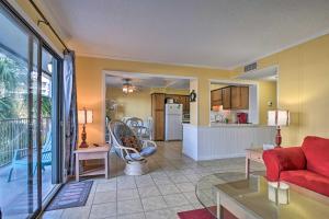 uma sala de estar com um sofá vermelho e uma cozinha em South Myrtle Condo with Balcony - Walk to the Beach! em Myrtle Beach
