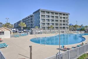 uma grande piscina com um grande edifício ao fundo em South Myrtle Condo with Balcony - Walk to the Beach! em Myrtle Beach