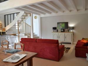 ein Wohnzimmer mit einem roten Sofa und einem Tisch in der Unterkunft Gîte Saint-Sulpice-de-Cognac, 2 pièces, 2 personnes - FR-1-653-139 in Saint-Sulpice-de-Cognac