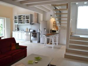 ein Wohnzimmer mit einem roten Sofa und einer Küche in der Unterkunft Gîte Saint-Sulpice-de-Cognac, 2 pièces, 2 personnes - FR-1-653-139 in Saint-Sulpice-de-Cognac