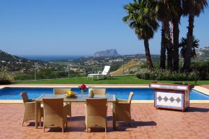 a patio with a table and chairs next to a pool at Finca Klara, Boutiquehotel - Apartment -Javea-Moraira- in Benitachell