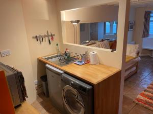 a kitchen with a washing machine and a sink at Hideaway@no3 in Thornton Dale