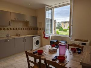 a kitchen with a wooden table and a window at Gîte charmant au cœur d'un château historique avec parc, proche de Cognac, idéal famille et nature - FR-1-653-167 in Cherves-de-Cognac +25 photos