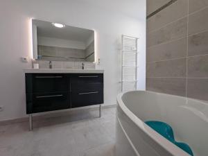 a bathroom with a tub and a sink and a mirror at Maison en pierres rénovée avec jardin, terrasse, 3 chambres, proche village, nature paisible, équipements complets - FR-1-653-187 in Montboyer +28 photos