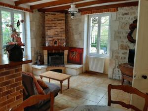 a living room with a fireplace and a brick wall at Gîte Champniers, 3 pièces, 4 personnes - FR-1-653-198 in Champniers