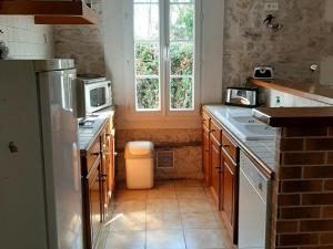 a kitchen with a sink and a refrigerator and a window at Gîte Champniers, 3 pièces, 4 personnes - FR-1-653-198 in Champniers