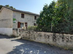 un antiguo edificio de piedra con una valla y un árbol en Gîte Champniers, 3 pièces, 4 personnes - FR-1-653-198, en Champniers