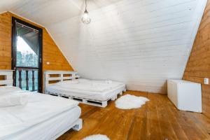 a attic room with two beds and a window at Wellness chata Sloupnice in Sloupnitz