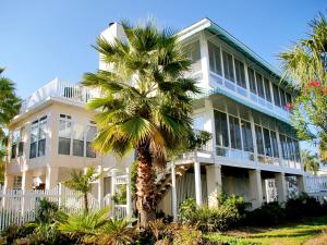 a large white building with a palm tree in front of it at Driftaway in Tybee Island