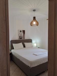 a bedroom with a bed and a chandelier at DeniaStella Apartments in Skala Potamias