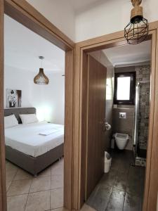 a bedroom with a bed and a bathroom with a toilet at DeniaStella Apartments in Skala Potamias