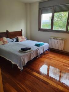 una camera con letto e pavimento in legno di Chalet en Somió con finca independiente a Gijón