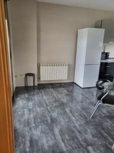 ein leeres Zimmer mit einem weißen Kühlschrank und einem Tisch in der Unterkunft Chalet en Somió con finca independiente in Gijón