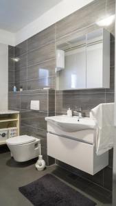 a bathroom with a white sink and a toilet at Apartments Bazina in Kaštela +85 photos