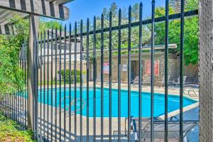 a fence with a pool in front of a building at Deluxe Townhome with Deck, 2 Mi to Downtown Modesto! in Modesto