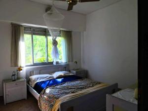 a bedroom with a bed and a window at Gaia Hostal in Tigre