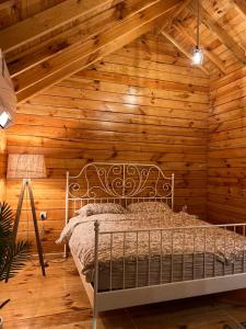 a bedroom with a bed in a wooden wall at أكواخ غيم ومطر in Al Hada