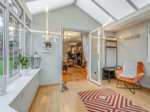 sala de estar de planta abierta con silla naranja y alfombra en Featherstone House, en Heighington