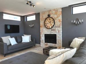 sala de estar con chimenea y reloj en la pared en Namaste en Ciudad del Cabo