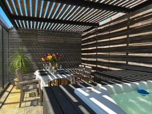 a patio with a table and chairs and a hot tub at Namaste in Cape Town