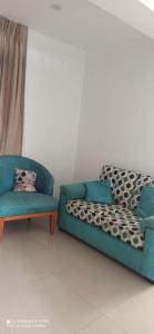 a blue couch and two chairs in a room at Hermosa departamento vanguardista c/ balcon . in Trujillo