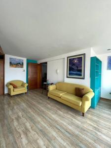 una sala de estar con 2 sofás amarillos en una habitación en Hermosa departamento vanguardista c/ balcon ., en Trujillo