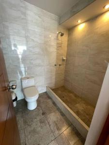 a bathroom with a toilet and a bath tub at Hermosa departamento vanguardista c/ balcon . in Trujillo