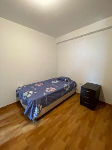 ein Schlafzimmer mit einem Bett und einem Tisch darin in der Unterkunft Hermosa departamento vanguardista c/ balcon . in Trujillo