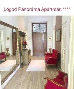 ブダペストにあるLogod Panorama Apartmanのリビングルーム(赤い椅子、鏡付)