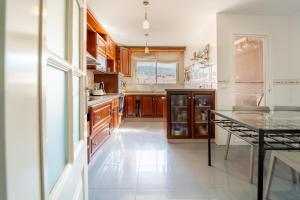 cocina con armarios de madera y mesa de cristal en Duplex Luz, en Jaén